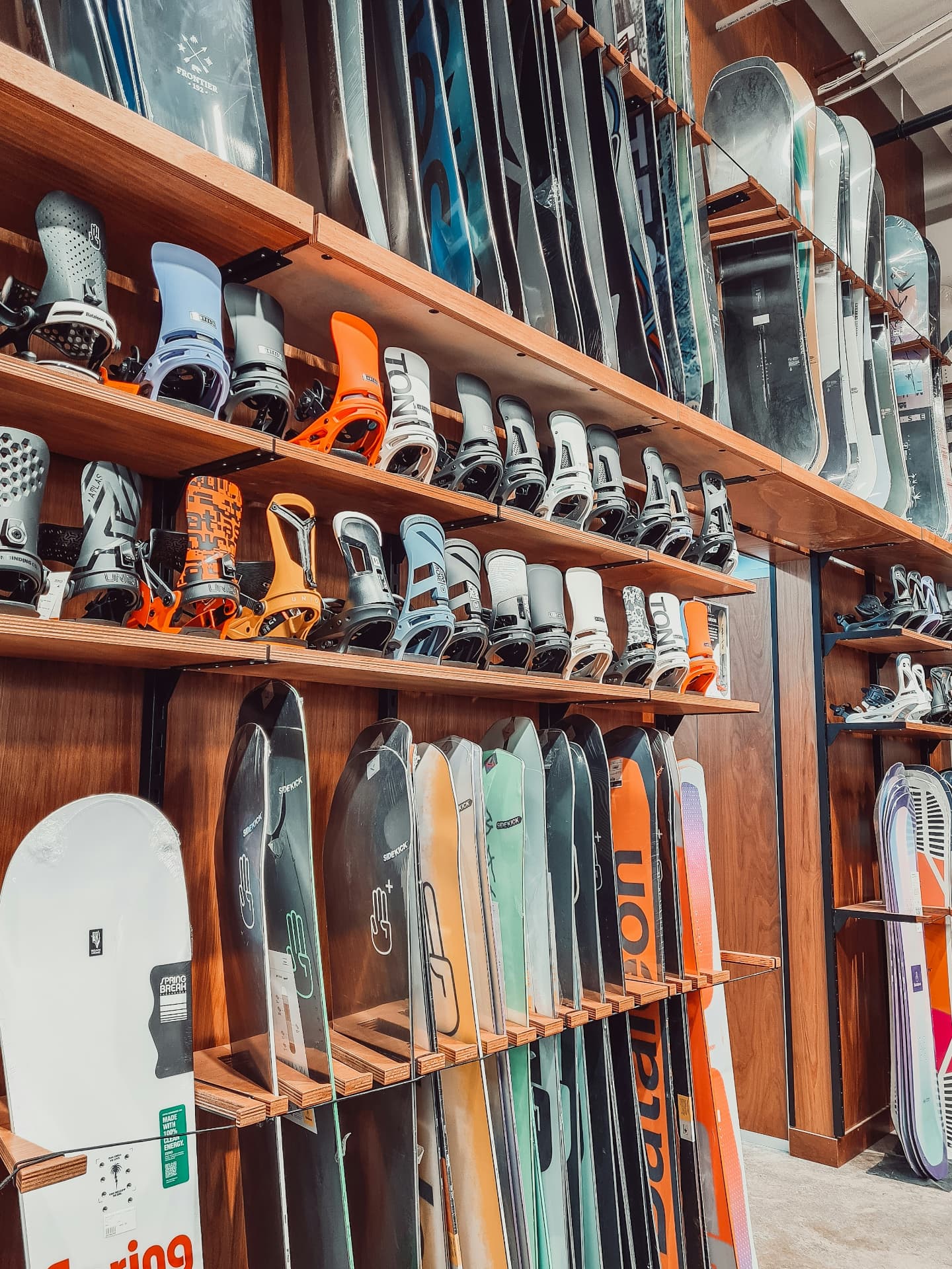 Skis and snowboards organized on the wall of an independent gear shop